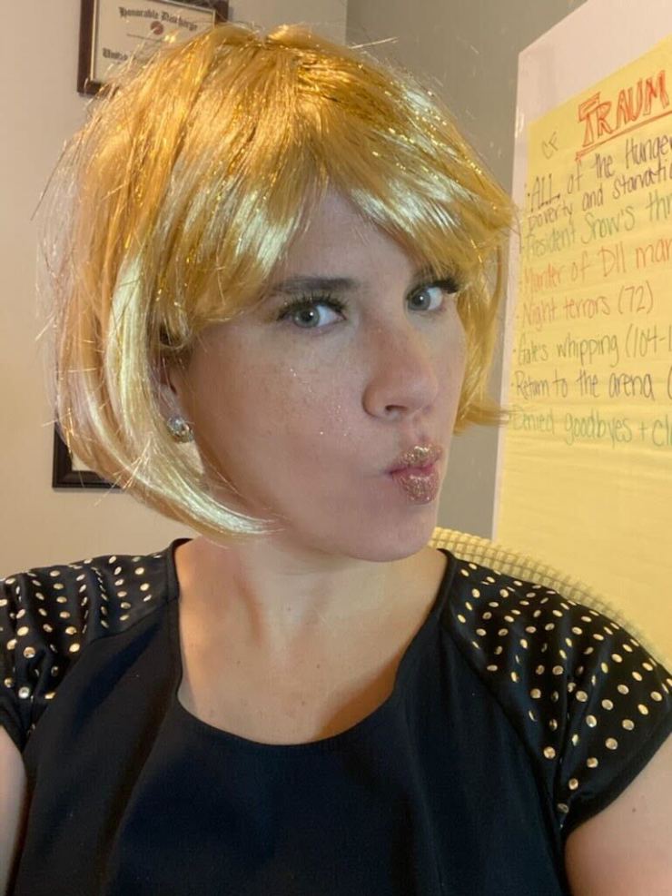 Teacher Caroline Kuhlman O'Neill wears a blonde wig and purses her lips.