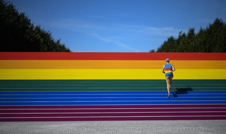 A man walks on steps covered in rainbow colors for Pride Month at Franklin D. Roosevelt Four Freedoms Park in New York City.