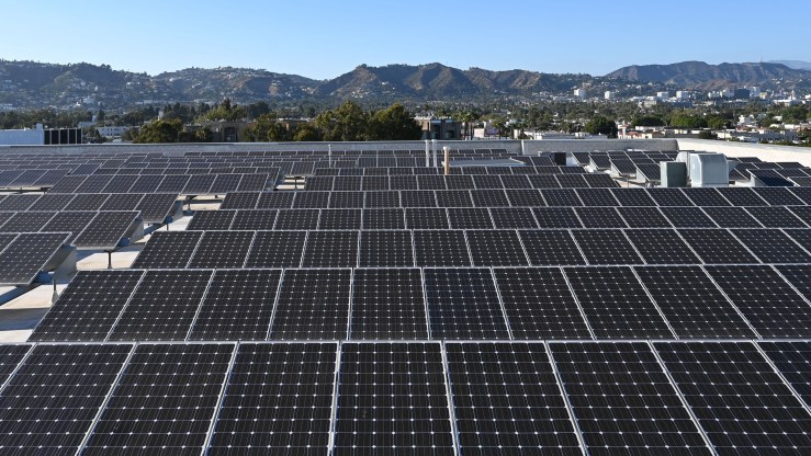 Rows of solar panels are seen on a roof.