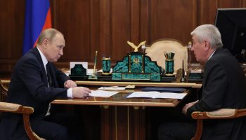Russian President Vladimir Putin, left, takes a meeting.