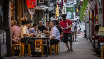 People eating outside a restaurant in Tokyo.