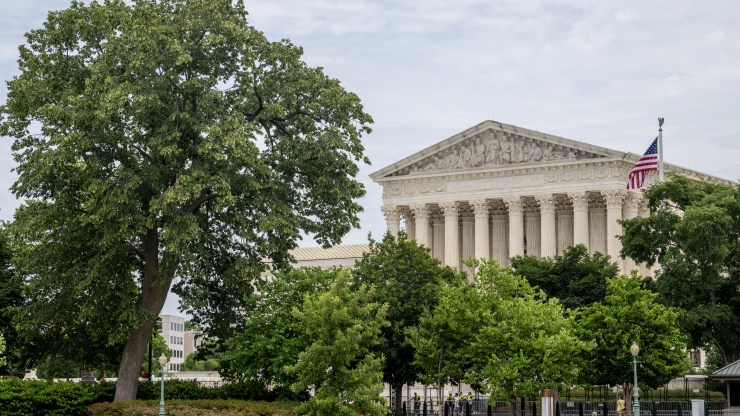 The U.S. Supreme Court is seen behind trees.