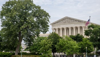 The U.S. Supreme Court is seen behind trees.