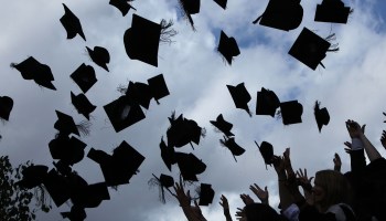 Students throw their graduation caps in the air.