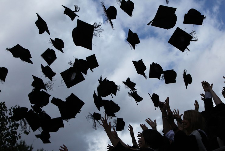 Students throw their graduation caps in the air.