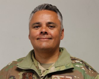 Chief Master Sgt. Cameron Pieters smiles in military attire.