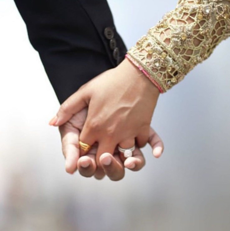 A photo of Sana and Adnan holding hands.
