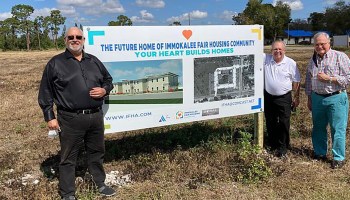 Arol Buntzman is seen with supporters of the project, smiling and standing in front of a sign advertising the Immokalee Fair Housing Alliance complex.