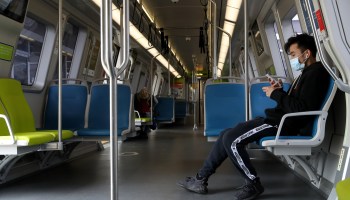One rider sits alone in a nearly empty subway car.