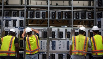Workers install a new row of bitcoin mining machines at the Whinstone US Bitcoin mining facility in Rockdale, Texas, in 2021.