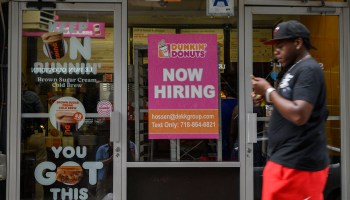 A man walks past a "Now Hiring" sign in New York City at a Dunkin' on July 8.