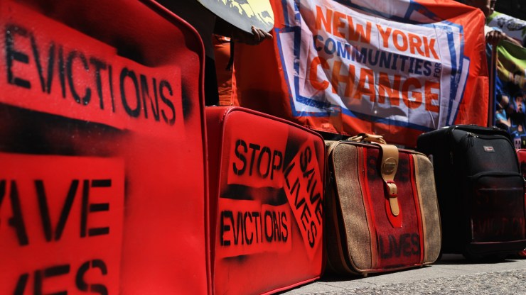 Luggage with the words "Stop Evictions Save Lives" written on them are seen as people gather outside of a New York City.