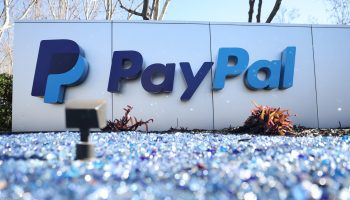 A white sign with the blue PayPal logo outside the PayPal headquarters.