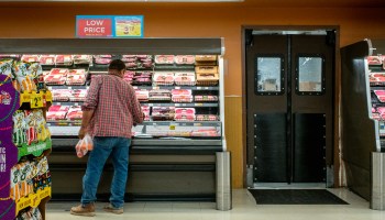 A customer shops in the meats section of a Kroger grocery store.