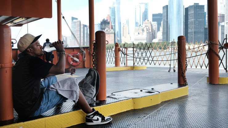 A man takes a drink of water while riding on the Staten Island Ferry on a sweltering afternoon.