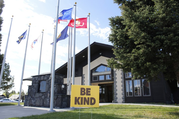 A "Be Kind" sign is posted at the West Yellowstone visitor's center