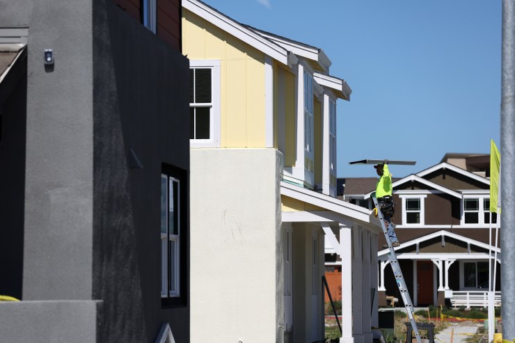 A construction worker carries materials as he works on a home under construction at a housing development on March 23, 2022 in Petaluma, California.