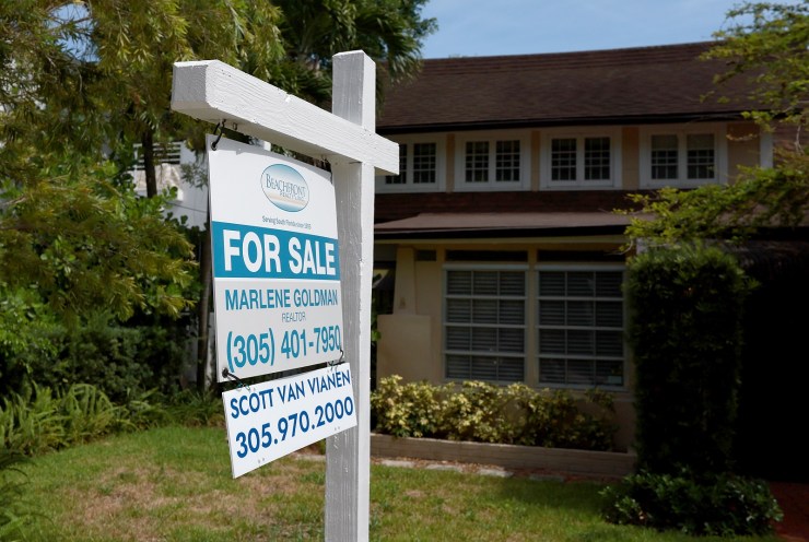 A "for sale" sign in the front yard of a two-story home in Miami.