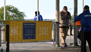 A man walks through a metal detector at a football stadium.