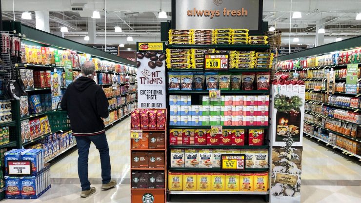 A customer walks down an aisle as he shops in a grocery story.