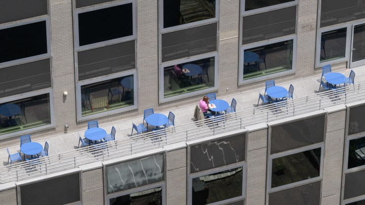 A person eats lunch on the terrace of a Manhattan office building.