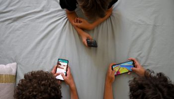 Teenagers hang on to their smartphones in Marseille, southern France, on June 27, 2022. In a new book, Harvard researchers Emily Weinstein and Carrie James explore the complex digital lives of teens.