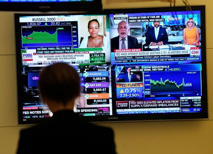 A person on the floor of the New York Stock Exchange watches TV screens on July 27 filled with financial news about the interest rate hike.