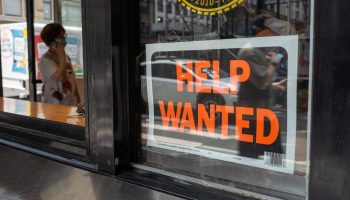 A help wanted sign displayed in a window