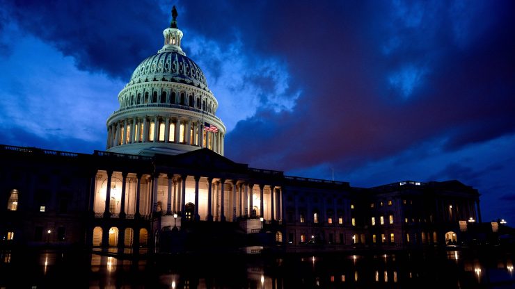 The U.S. Capitol on Aug. 6, windows lit, against a dark, cloudy sky.
