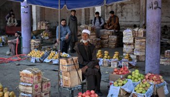 Fruit vendors wait for customers at a market in Kabul on August 9,