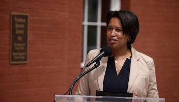 D.C. Mayor Muriel Bowser stands behind a lectern while speaking at a news conference.