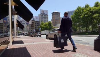 A pedestrian carrying a shopping bag in San Francisco.