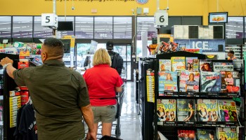 Customers wait in a check-out line at a Kroger grocery store in July in Houston.