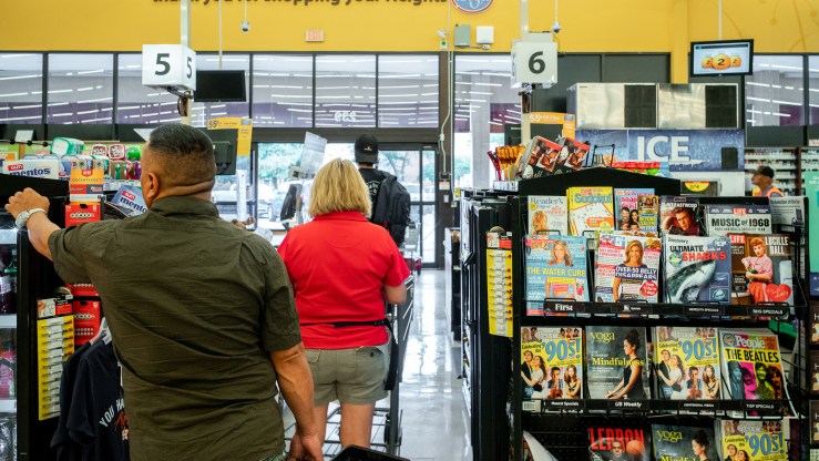 Customers wait in a check-out line at a Kroger grocery store in July in Houston.
