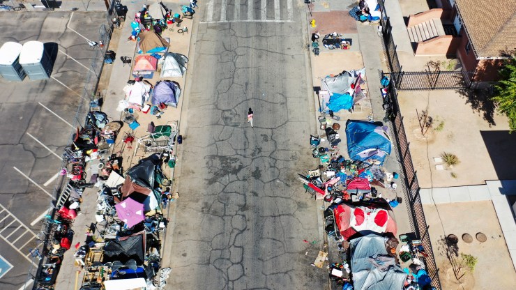 An aerial view of people gathered near a homeless encampment in the afternoon heat on July 21 in Phoenix,.