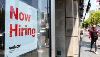 A 'Now Hiring' sign posted at a Verizon store on in July in Los Angeles.