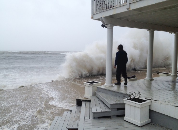A wave crashes against the shore of a porch in Montauk. 
