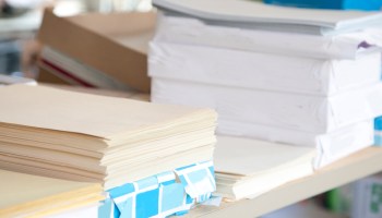Stacks and reams of white and cream-colored paper.
