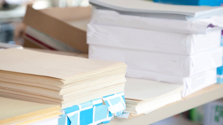 Stacks and reams of white and cream-colored paper.