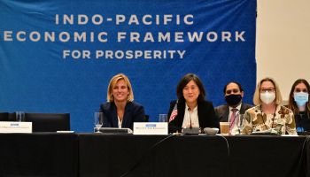 U.S. Trade Representative Katherine Tai sits at a panel table with other diplomats. A blue banner behind them reads "Indo-Pacific Economic Framework for Prosperity."
