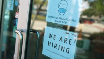 A "We are hiring" sign in front of a store in Miami.