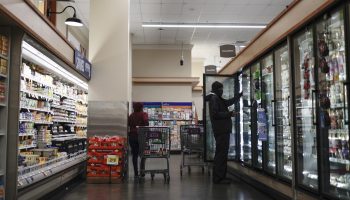 Two shoppers in the frozen aisle at a supermarket.