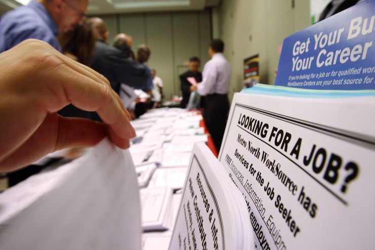 Job seekers look through listings at a career fair