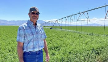 Marty Plaskett, a hay farmer in Diamond Valley, Nevada, stands near one of the irrigation pivots that waters his alfalfa field on Sept. 2, 2022.