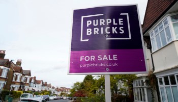 A Purple Bricks for sale sign is posted outside a two-level home with a bay window in south London on Oct. 3.
