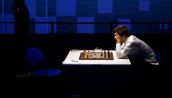 Magnus Carlsen looking at a chess board.