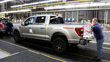 An employee works on a Ford truck on an assembly line.