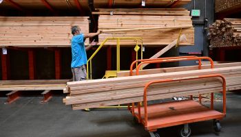 A man loads pieces of two-by-four wood onto his cart in the lumber section at a home improvement store on August 16, 2022 in Alhambra, California.