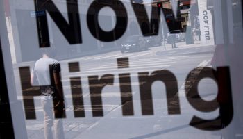 LOS ANGELES, CALIFORNIA - AUGUST 06: A 'Now Hiring' sign is posted at a 7-Eleven store with a pedestrian reflected in the window on August 06, 2021 in Los Angeles, California. The U.S. economy added over 900,000 jobs in July, the biggest monthly gain since August of last year. (Photo by Mario Tama/Getty Images)