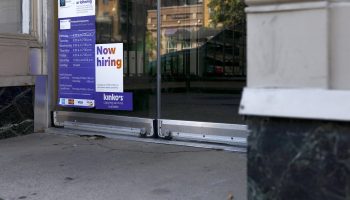 A "Now Hiring" sign is displayed in front of a FedEx store on October 07, 2022 in Washington, DC.